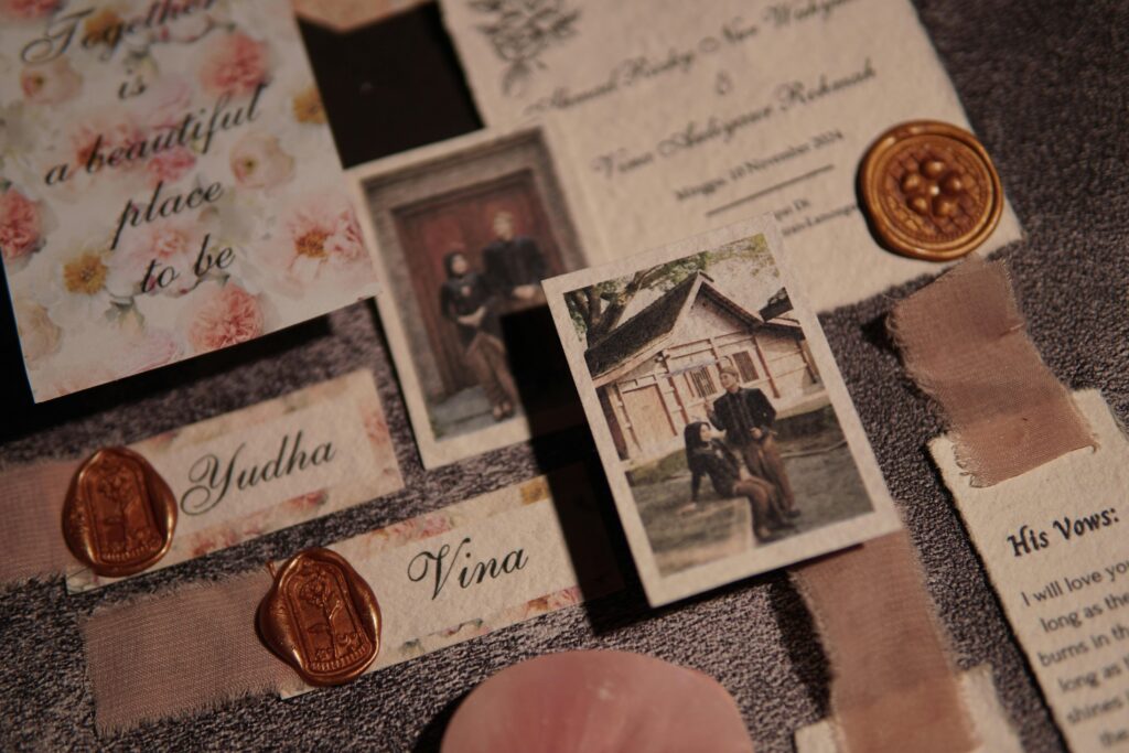 A vintage wedding invitation set featuring floral designs and wax seals, capturing a romantic theme.