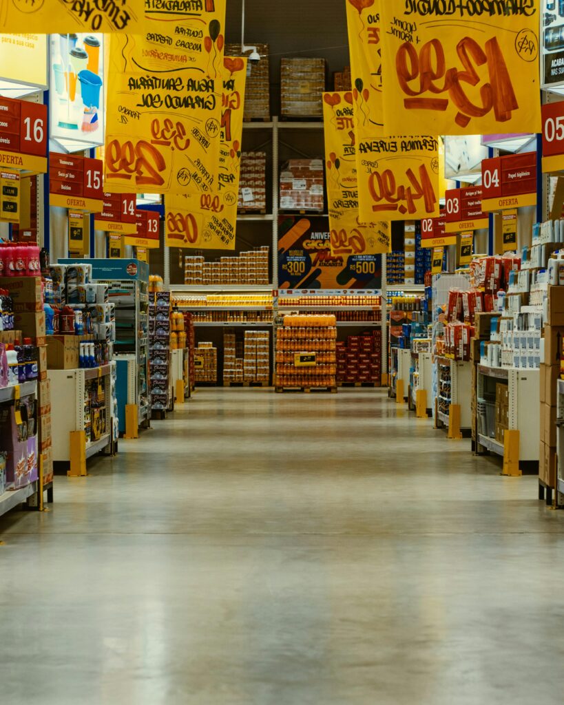 Wide supermarket aisle with colorful sale banners and stocked shelves in a vibrant Brazilian store.